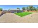 Large backyard featuring artificial turf, a covered patio, and low-maintenance desert landscaping at 1716 W Villa Theresa Dr, Phoenix, AZ 85023