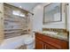 Bathroom showcasing a tub with shower, stylish vanity, and wood-look tile at 1716 W Villa Theresa Dr, Phoenix, AZ 85023