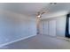 Bedroom showcasing neutral-colored walls and carpet, ceiling fan, and a closet with sliding doors at 1716 W Villa Theresa Dr, Phoenix, AZ 85023