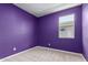 Bedroom featuring neutral carpet, a window, and an eye-catching purple paint at 17352 W Red Fox Rd, Surprise, AZ 85387