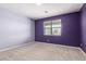 Cozy bedroom with plush carpeting, natural light from a large window, and a calming ambiance at 17352 W Red Fox Rd, Surprise, AZ 85387