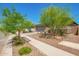 Charming home featuring a spacious driveway, two car garage, and desert landscaping at 17352 W Red Fox Rd, Surprise, AZ 85387