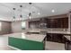Beautiful kitchen featuring dark cabinetry, granite counters, and an island with seating at 17352 W Red Fox Rd, Surprise, AZ 85387