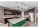 Bright kitchen featuring an island with seating, granite counters, and pendant lighting at 17352 W Red Fox Rd, Surprise, AZ 85387