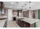 Stylish kitchen featuring dark cabinets, granite counters, and stainless-steel appliances at 17352 W Red Fox Rd, Surprise, AZ 85387