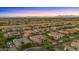 An aerial view of a community with neatly landscaped yards, neighborhood pools and scenic mountain views at 17850 E Bronco Ct, Queen Creek, AZ 85142