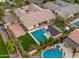 Aerial view of backyard oasis with pool, spa, covered patio, and lush landscaping, ideal for relaxation and gatherings at 17850 E Bronco Ct, Queen Creek, AZ 85142