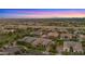 An aerial view of a neighborhood showing well maintained landscaping, pools and mountain views at 17850 E Bronco Ct, Queen Creek, AZ 85142