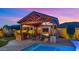 Outdoor living space with seating, fireplace, outdoor kitchen, hot tub and pool at 17850 E Bronco Ct, Queen Creek, AZ 85142