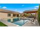 Beautiful backyard with a sparkling pool, covered patio with outdoor seating and lush landscaping at 17850 E Bronco Ct, Queen Creek, AZ 85142