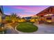 Expansive backyard featuring covered outdoor kitchen and seating area and lush landscaping at 17850 E Bronco Ct, Queen Creek, AZ 85142