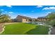 Spacious backyard featuring a pool, green lawn and a covered patio, perfect for outdoor entertaining at 17850 E Bronco Ct, Queen Creek, AZ 85142