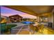 Expansive outdoor space with fireplace, grill, pool and manicured lawn at 17850 E Bronco Ct, Queen Creek, AZ 85142