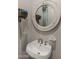 Close-up of bathroom sink with brushed bronze faucet, round mirror, and decor at 17850 E Bronco Ct, Queen Creek, AZ 85142