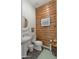Powder room featuring wood accent wall, pedestal sink, and stylish decor at 17850 E Bronco Ct, Queen Creek, AZ 85142