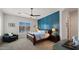 Cozy bedroom with a blue accent wall, wood furniture, and abundant natural light from the large window at 17850 E Bronco Ct, Queen Creek, AZ 85142