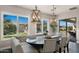Bright dining room features modern light fixtures, custom seating, and views of the outdoor space at 17850 E Bronco Ct, Queen Creek, AZ 85142