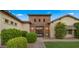 Stunning front exterior with a brick accent tower, lush landscaping, and an inviting entryway at 17850 E Bronco Ct, Queen Creek, AZ 85142
