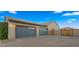Spacious three-car garage with blue doors and ample parking space on the paved driveway at 17850 E Bronco Ct, Queen Creek, AZ 85142