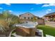 Landscaped backyard featuring a hot tub with artificial grass and tropical plants under a bright blue sky at 17850 E Bronco Ct, Queen Creek, AZ 85142