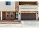 Modern townhome with a brown garage door and stone accents on the exterior facade at 2000 N 36Th St # 19, Phoenix, AZ 85008