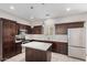 Well-lit kitchen with island, stainless steel appliances, and dark brown cabinets at 2000 N 36Th St # 19, Phoenix, AZ 85008