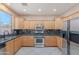 Kitchen featuring stainless steel appliances, granite countertops, and light wood cabinets at 20277 N 68Th Dr, Glendale, AZ 85308