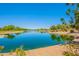 Beautiful lake view with serene water, lush landscaping, and a glimpse of a lakeside house at 20277 N 68Th Dr, Glendale, AZ 85308