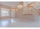 Bright and spacious living room featuring tile floors, staircase, and a chandelier at 20277 N 68Th Dr, Glendale, AZ 85308