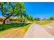 Scenic view of a paved walking path lined with trees and well-maintained landscaping in community at 20277 N 68Th Dr, Glendale, AZ 85308