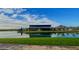 Scenic view of a modern clubhouse on a lake with mountain views and manicured landscaping at 23068 E Stacey Rd, Queen Creek, AZ 85142
