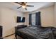Cozy bedroom with ceiling fan, TV, dark curtains, and a black dresser at 2319 N 71St Dr, Phoenix, AZ 85035