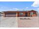 Charming single-story home showcasing a two-car garage, solar panels, and desert landscaping at 2319 N 71St Dr, Phoenix, AZ 85035