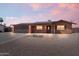 Charming single-story home showcasing a two-car garage, solar panels, and desert landscaping at dusk at 2319 N 71St Dr, Phoenix, AZ 85035