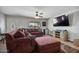 Inviting living room featuring a comfortable brown sofa, ceiling fan, and wall-mounted television at 2319 N 71St Dr, Phoenix, AZ 85035
