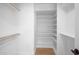 Spacious walk-in closet with white shelving and wood-look flooring at 2712 N 20Th Dr, Phoenix, AZ 85009