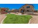 Large backyard boasts a playset, patio dining, trampoline and a grassy lawn, perfect for entertaining at 3016 W White Canyon Rd, San Tan Valley, AZ 85144