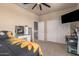 A bedroom with tan walls with ceiling fan, TV, desk area, and closet at 3016 W White Canyon Rd, San Tan Valley, AZ 85144
