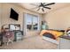 A neutral-toned bedroom features a large window, ceiling fan, TV, and desk area at 3016 W White Canyon Rd, San Tan Valley, AZ 85144