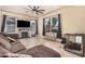 Cozy living room with a modern ceiling fan, fireplace, and comfortable brown sectional couch at 3016 W White Canyon Rd, San Tan Valley, AZ 85144