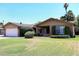Inviting single-story home with lush green lawn and brick accents, enhanced by mature palm trees at 3033 W Tierra Buena Ln, Phoenix, AZ 85053