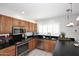 Kitchen showcasing dark countertops, stainless steel appliances, and oak cabinetry at 3033 W Tierra Buena Ln, Phoenix, AZ 85053