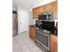 Modern kitchen with stainless steel appliances, wood cabinetry, and granite countertops at 3033 W Tierra Buena Ln, Phoenix, AZ 85053