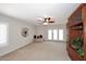 Bright living room with a ceiling fan, neutral carpet, and access to the backyard patio at 3033 W Tierra Buena Ln, Phoenix, AZ 85053