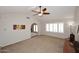 Large living room boasts neutral carpet, vaulted ceiling, shuttered windows, and an open archway entrance at 3033 W Tierra Buena Ln, Phoenix, AZ 85053