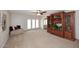 Bright living room with a large built-in cabinet, plush carpeting, and access to the backyard through French doors at 3033 W Tierra Buena Ln, Phoenix, AZ 85053
