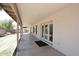 Covered patio with ceiling light, white brick wall, and double doors leading to the backyard at 3033 W Tierra Buena Ln, Phoenix, AZ 85053