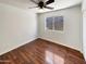 Hardwood floors in a well-lit bedroom with a ceiling fan and a window with backyard views at 317 E Nunneley Rd, Gilbert, AZ 85296