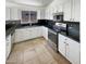 Well-lit kitchen showcasing modern appliances, dark countertops, and ample cabinet space for efficient cooking and storage at 317 E Nunneley Rd, Gilbert, AZ 85296