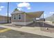 Tan single Gathering home displaying a carport in a neighborhood of similar homes with blue skies overhead at 320 E Mckellips Rd # 245, Mesa, AZ 85201